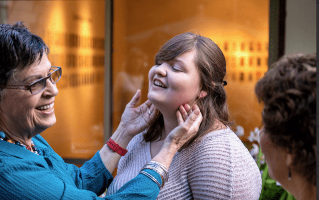 woman admiring student's earrings