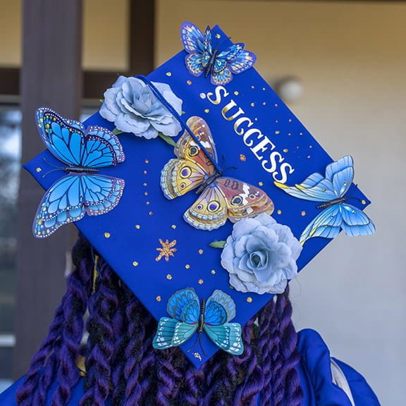 mortarboard with colorful butterflies and the word "success"